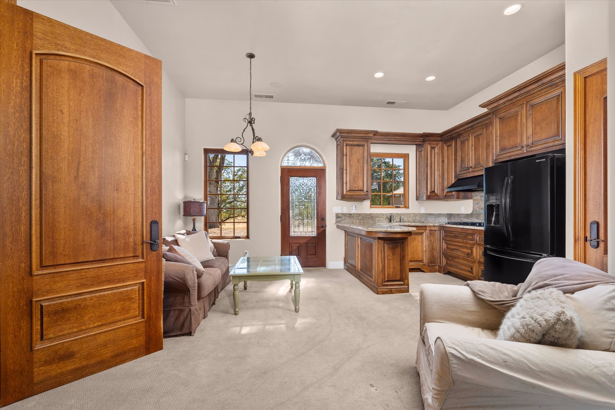 The living area of the attached guest house, with timber doors, a vaulted ceiling and its own entry.