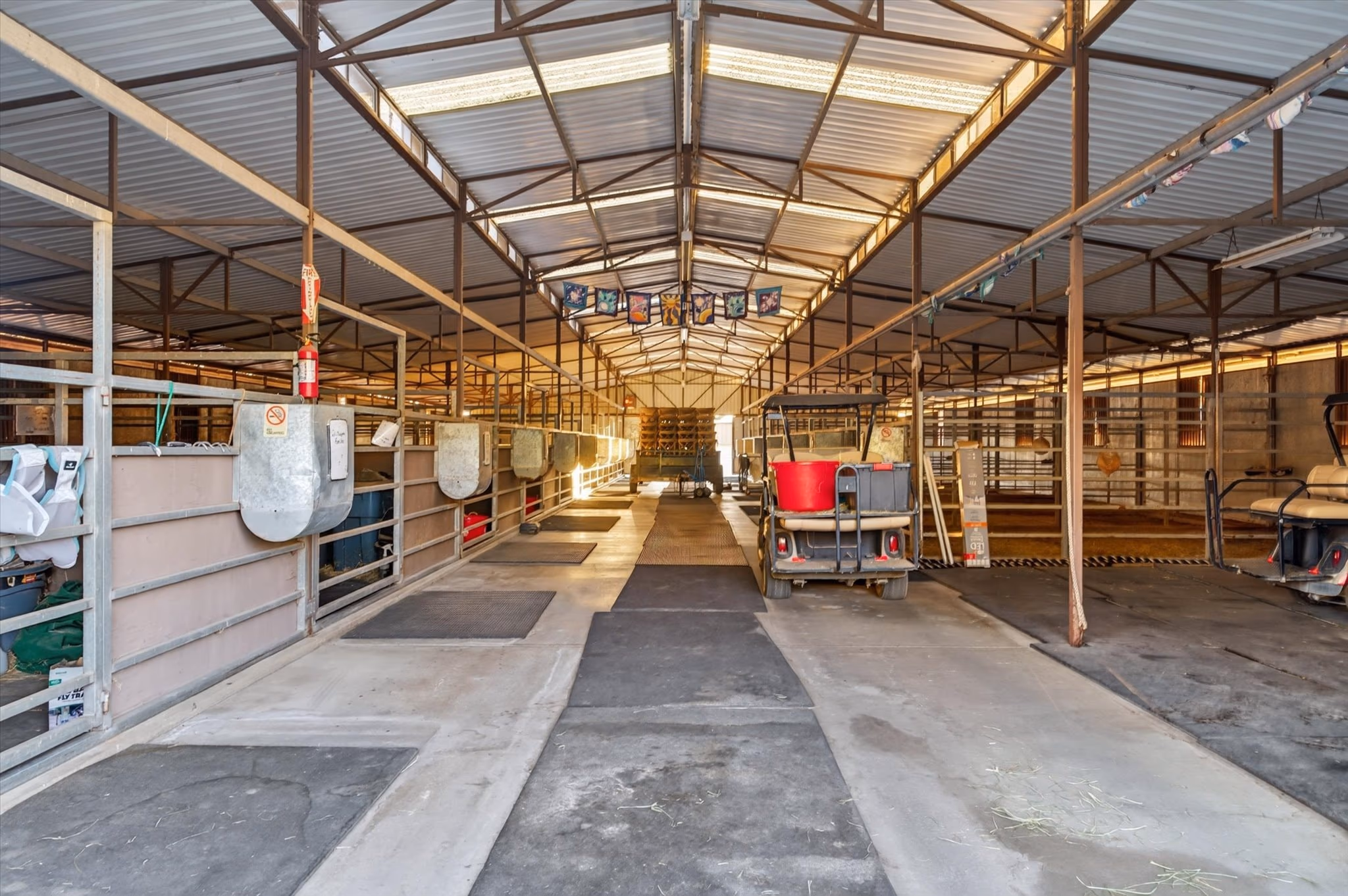 The central aisle of the show barn, running the length of the building with stalls and wash racks on both sides.
