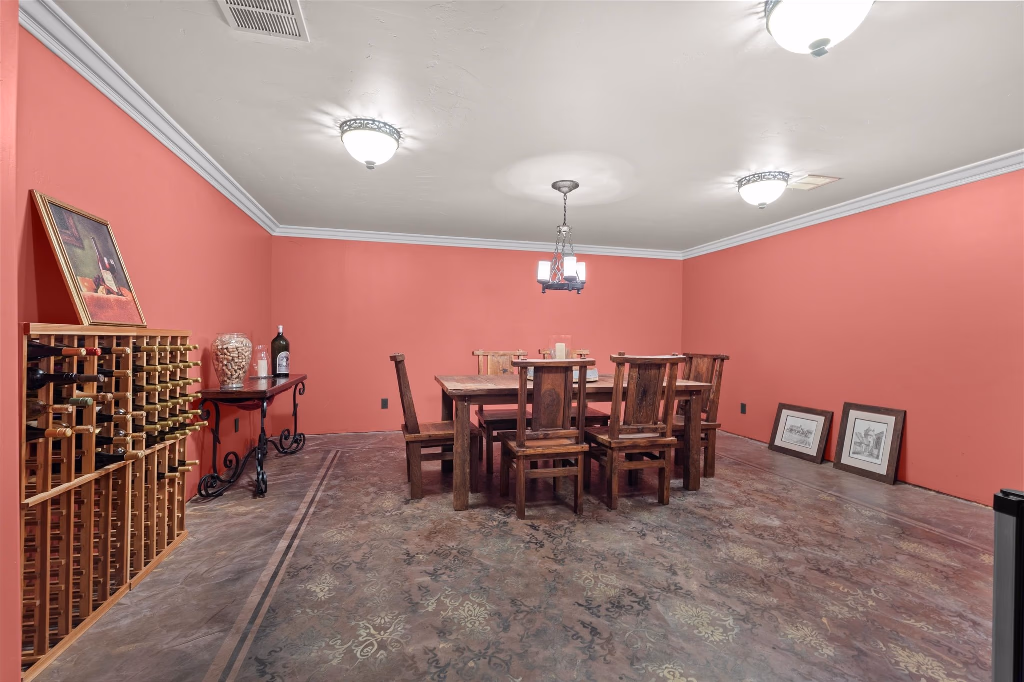 The wine cellar, with timber bottle racking along one wall, two tasting tables and a stained concrete floor.